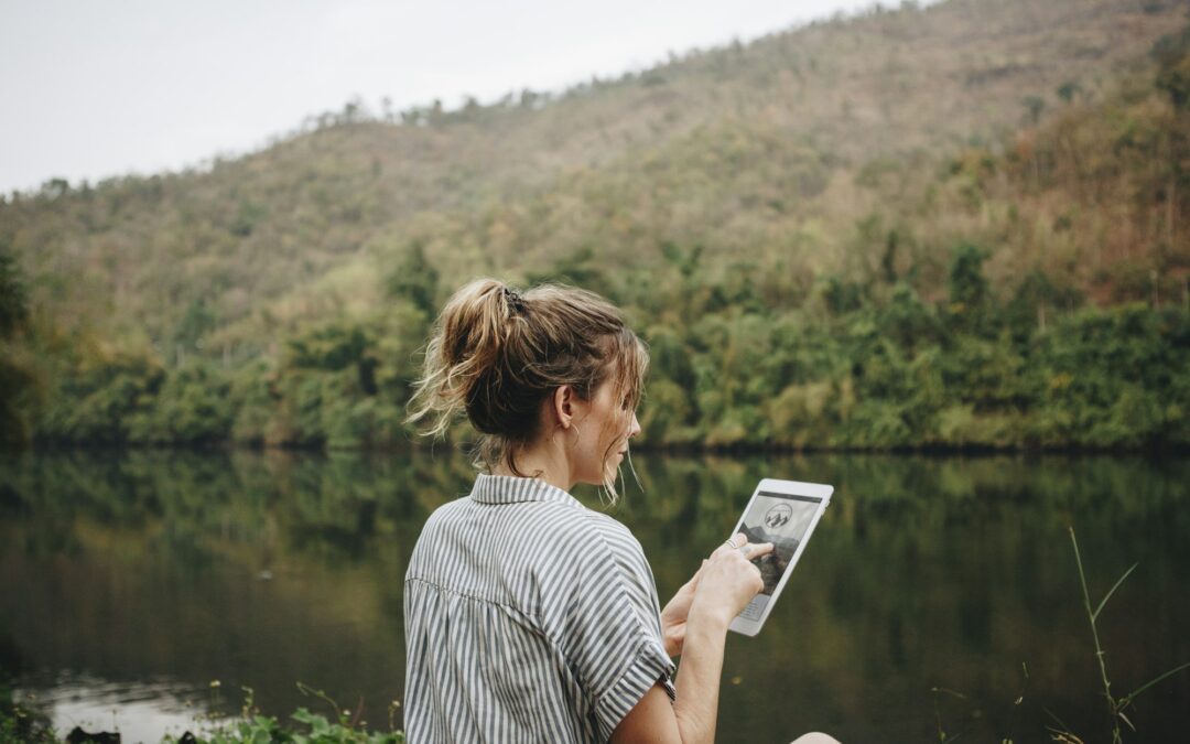 Woman alone in nature using a digital tablet internet connection and travel concept